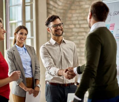 happy-coworkes-shaking-hands-after-business-presentation-office-min happy-coworkes-shaking-hands-after-business-presentation-office-min